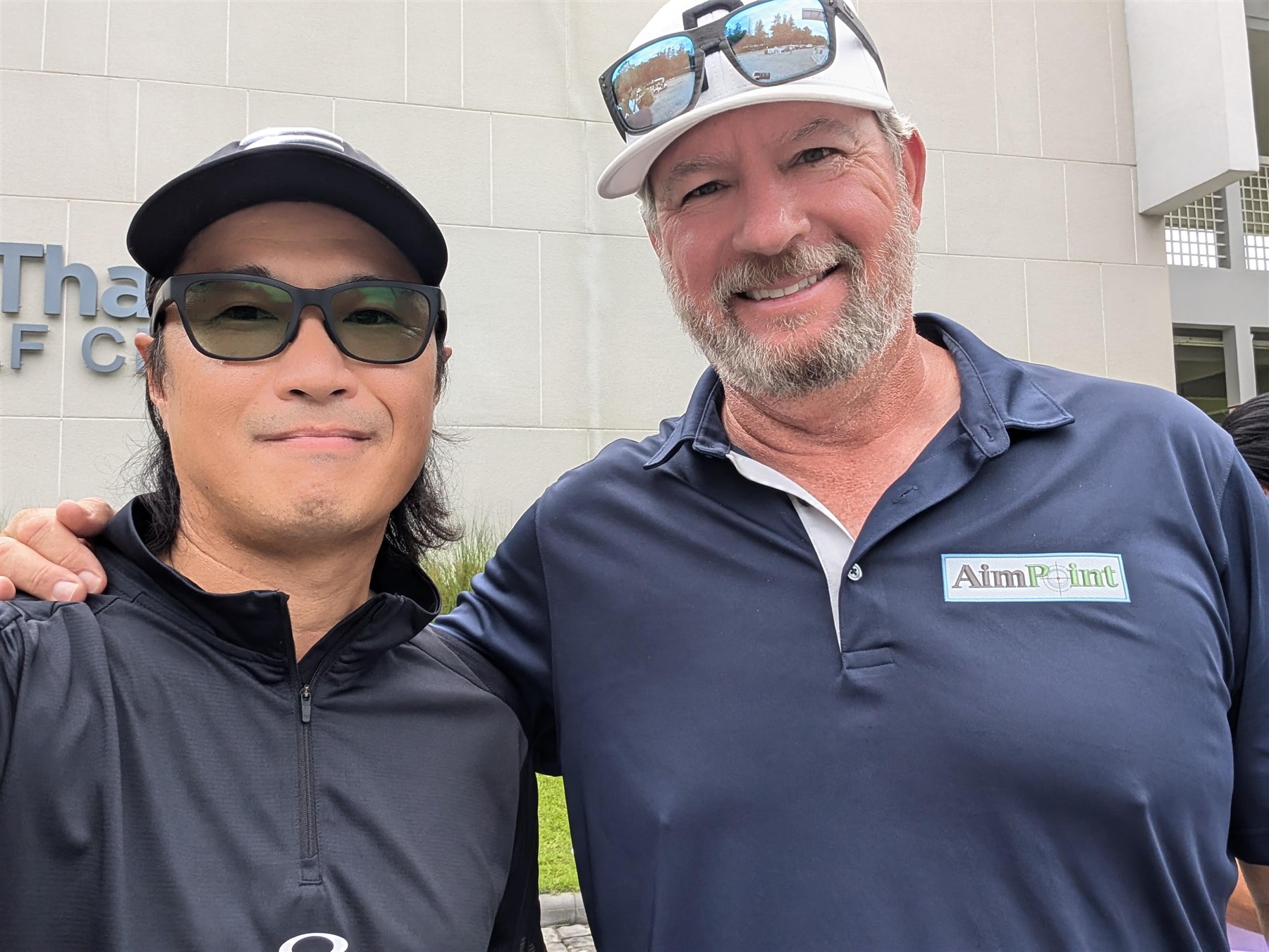 AimPointの研修会場で講師と並ぶ石原健太郎